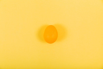 Minimal one pastel yellow egg. Happy Easter monochrome minimal greeting card concept. Flat lay, top view, horizontal orientation