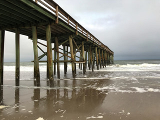 stormy blue sky pier on the beach waves