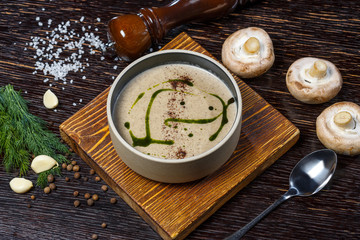 Obraz na płótnie Canvas Mushroom soup on a wooden board. Garlic, mushrooms, a tablespoon, dill and spices.