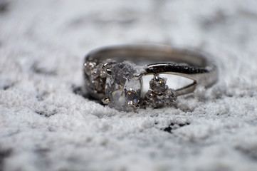 Silver ring for engagement to precious stones on blurred background