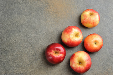 whole red ripe apples on a gray background