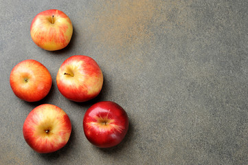 whole red ripe apples on a gray background