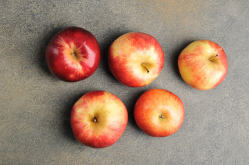  whole red ripe apples on a gray background