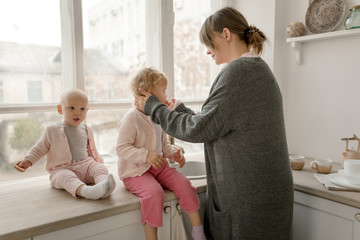 A young mother spends time with her little daughters at home.