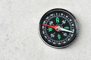 compass with a red magnetic arrow on a gray background with space for text