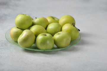 green whole juicy apples on a plate