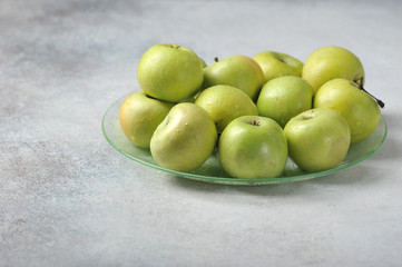 green whole juicy apples on a plate