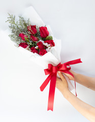 Hand holding a bouquet of beautiful red roses On a white background to congratulate and give as a gift instead of love.concept
