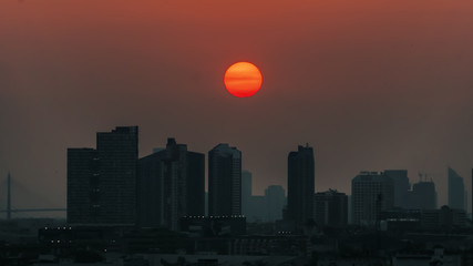 Fototapeta premium Bangkok sunset, falling sun over big city with huge buildings