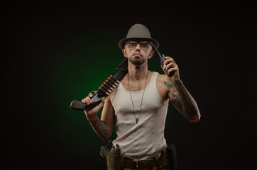 athletic guy with a tattoo poses with a shotgun