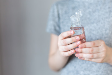 Close- up view of a little girl using a small portable antibacterial hand sanitizer. hand sanitizer gel for hand hygiene spread protection.