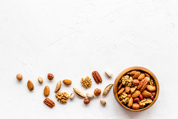 Mixed nuts in bowl - healthy snack - on white background top-down frame copy space