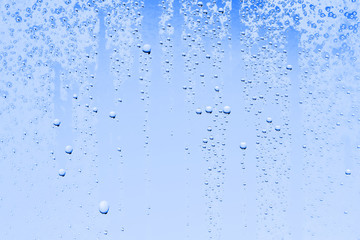 Naklejka na ściany i meble fresh drops background blue glass / wet rainy background, water drops transparent glass blue