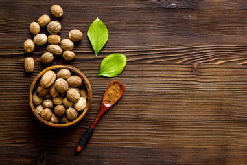 Nutmeg - spices in powder and whole nuts - on wooden background top-down copy space