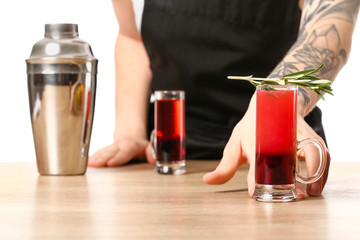 Female bartender with alcohol at table, closeup