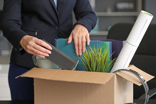 Fired mature woman packing personal stuff in office