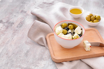 Tasty feta cheese with olives on grey background