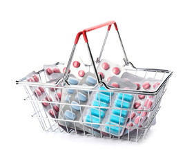 Small shopping basket with pills on white background
