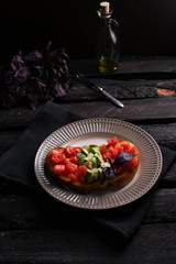 homemade bruschetta with tomatoes, avocado, olive oil on a toast, on a dark wooden background