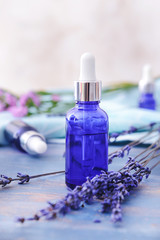 Bottle with lavender essential oil on table