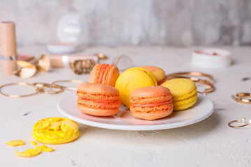 Plate with tasty macarons on table