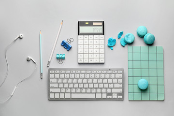 Stationery and computer keyboard with tasty macarons on white background