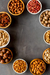 Nuts set in bowls on grey background top-down frame copy space mockup