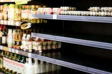 Empty egg shelves in a grocery store or supermarket. Hoarding food due to Coronavirus outbreak. Prepare food supplies for the worst case of COVID-19 pandemic. Stockpiling crisis all around the world.