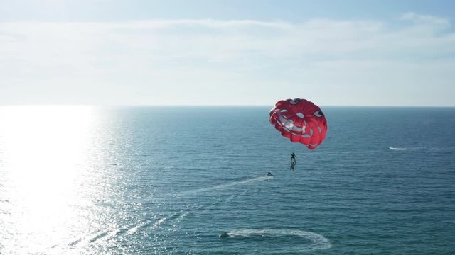 Travelers parasailing over the ocean water in the afternoon at Karon beach, Phuket, Thailand
