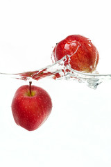 Apples falling in water with a splash.