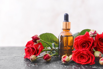 Obraz na płótnie Canvas Bottle with rose essential oil on table