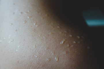 naked female shoulder with water drops