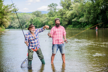 Dynamic Hobbies. two happy fisherman with fishing rod and net. Camping on the shore of lake. hunting tourism. father and son fishing. Fly Fishing Time. hobby. Big game fishing. friendship