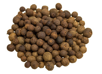 Spices allspice peas in glass plate on wooden background