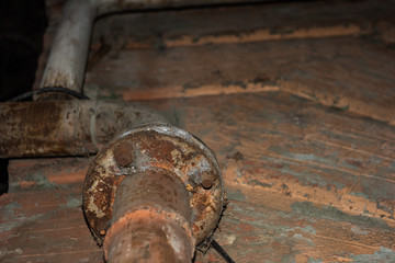 Industrial pipe with bolts against an old wall