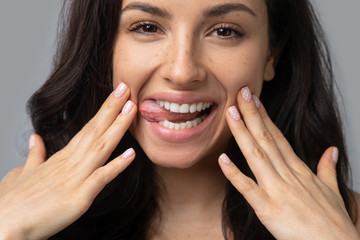 Beautiful dark-haired girl doing face yoga and smiling © zinkevych