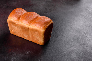 Fresh baked white bread on a brown concrete background