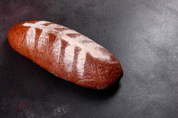 Fresh baked brown bread on a brown concrete background