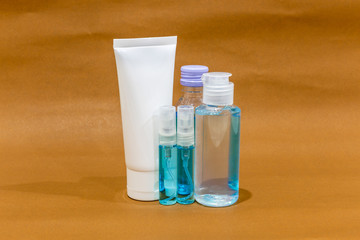 Bottle of antiseptic hand gel, alcohol and alcohol spray on brown background. Disease kill set for corona virus or covid-19 protection.