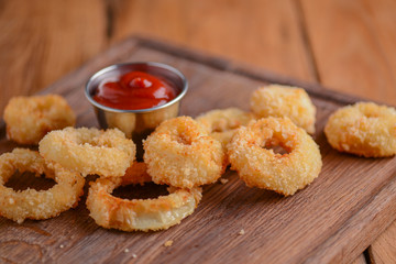 Golden crispy onion rings coated with breadcrumbs and deep fried. Fast food, junk food concept.