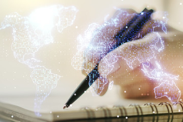 Double exposure of abstract digital world map and woman hand writing in notepad on background, big data and blockchain concept