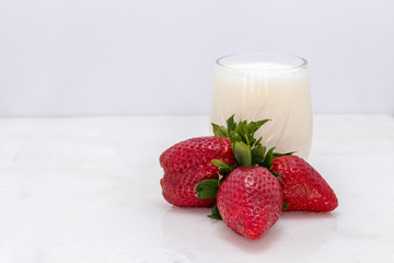 Fresh strawberries with milk on a white background