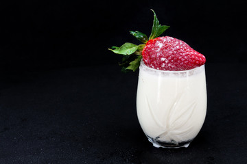 Fresh strawberries with milk on a black background
