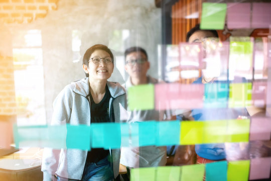 Asian Business Woman Leader And  Team  Wearing Casual Outfit Meeting  With Business Partner Using Note Paper For Present Idea.Agile And Scrum Meeting