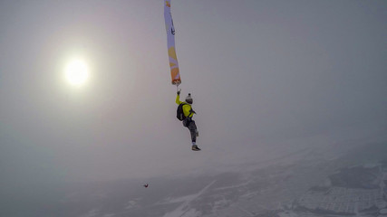 Investment. Parachutist performs an acrobatic trick in the air. Flying men make professional jump. Extreme as a hobby. 