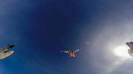 Investment. Parachutist performs an acrobatic trick in the air. Flying men make professional jump. Extreme as a hobby. 