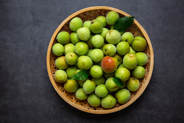 Freshly green plum on dark gray background.