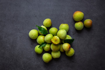 Freshly green plum on dark gray background.