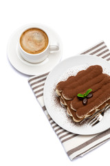 Classic tiramisu dessert on ceramic plate and cup of coffee isolated on white background with clipping path