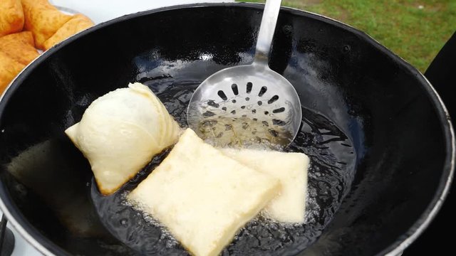 Fry the chebureks with meat in frying pan with hot oil